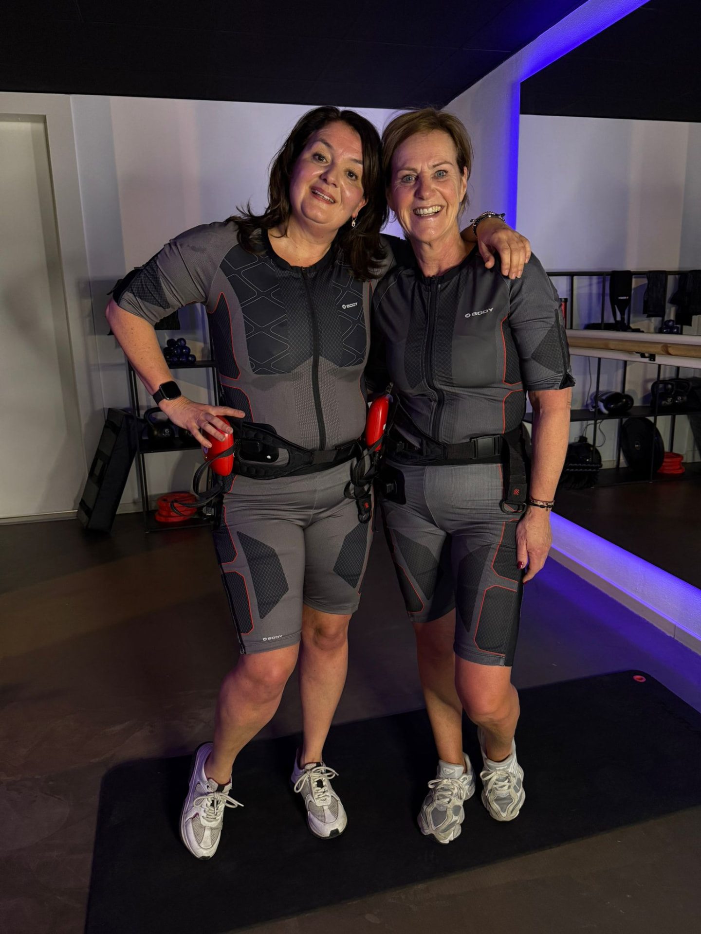 Twee vrouwen in EMS-pakken in de studio